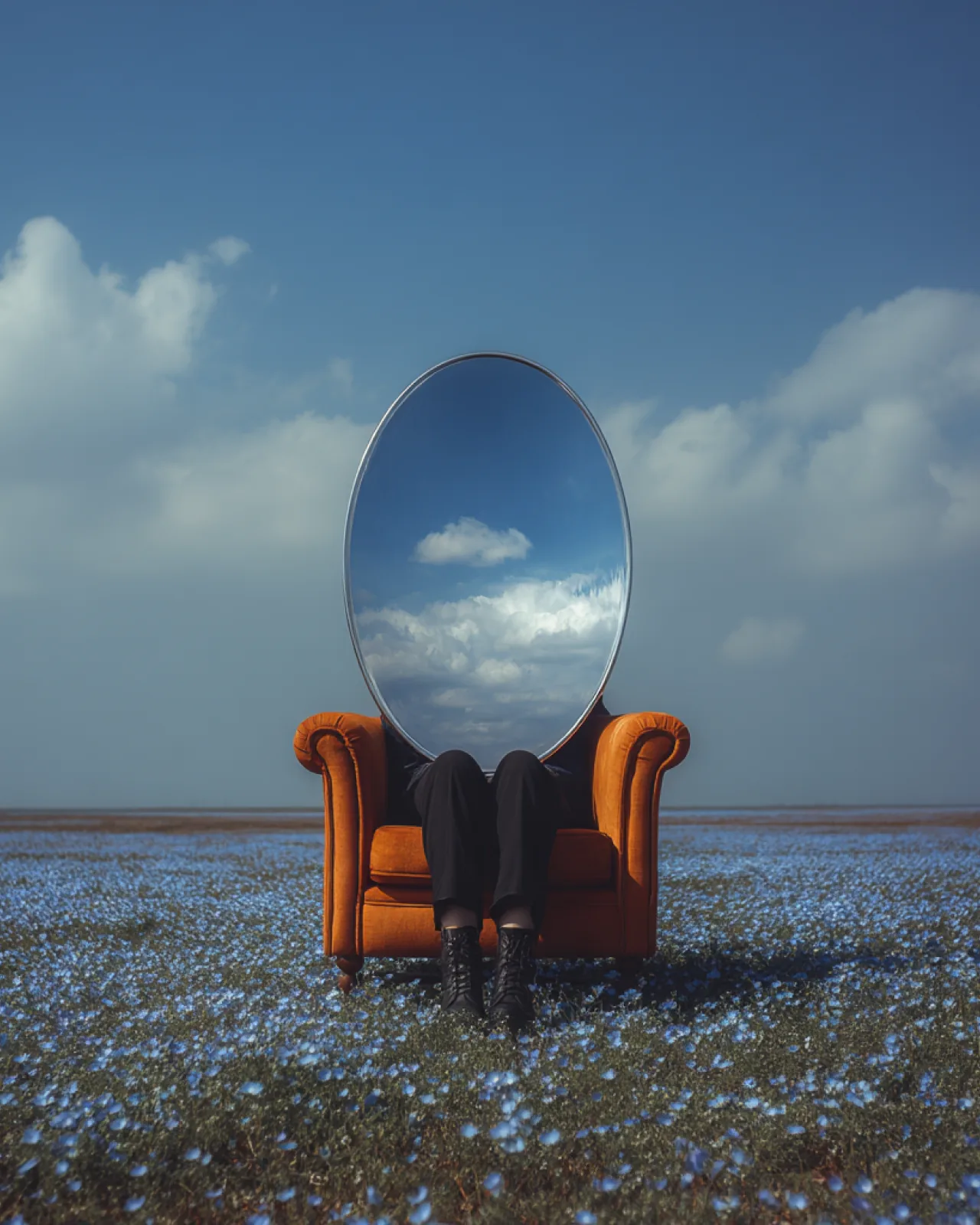 A mirror propped on an armchair in a field of flowers