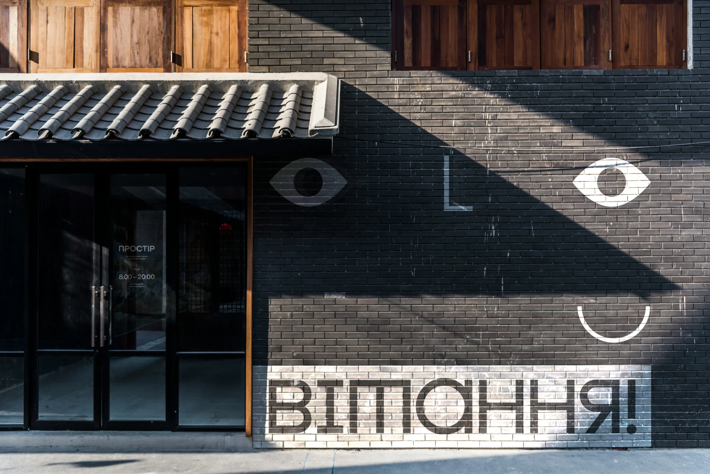 Hub exterior with eye and mouth signage and a Ukrainian greeting