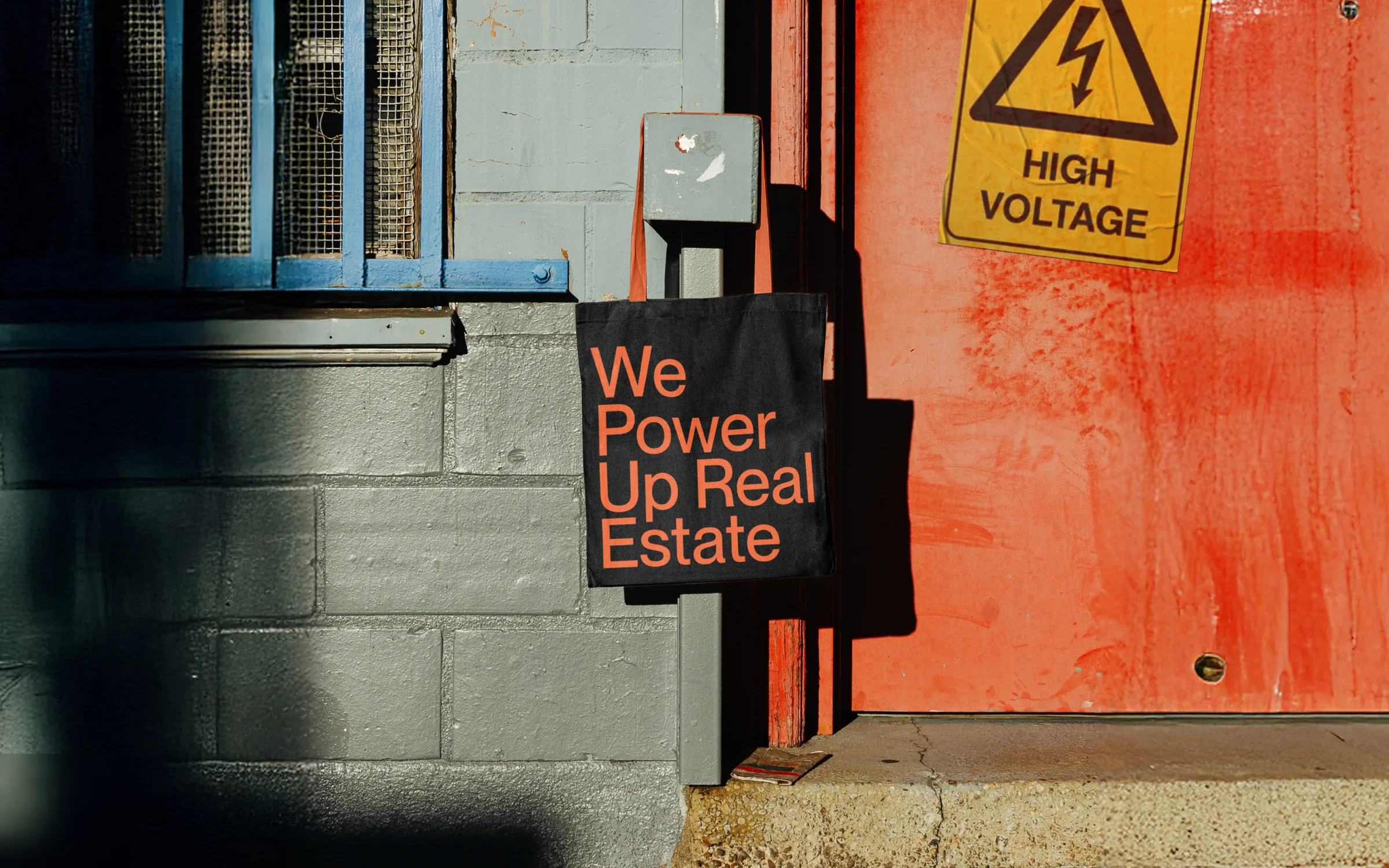 A We Power Up Real Estate tote in an industrial doorway